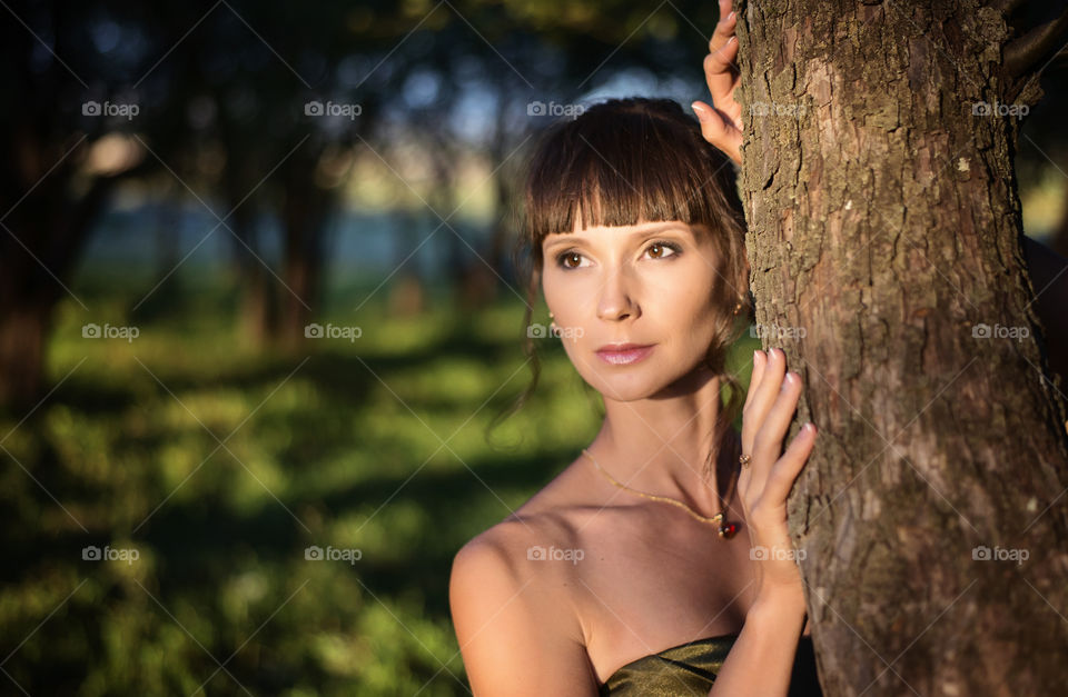 Portrait of woman standing near the tree
