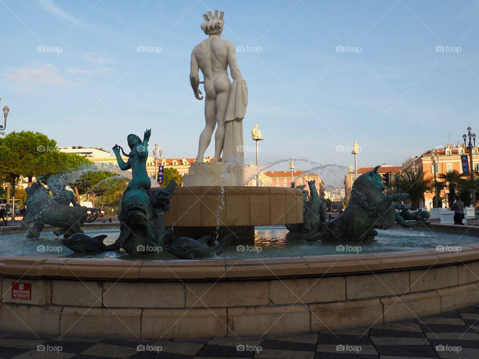 Sun fountain with statue of Apollo and mythological bronze figures on the Place Massena in Nice, France.