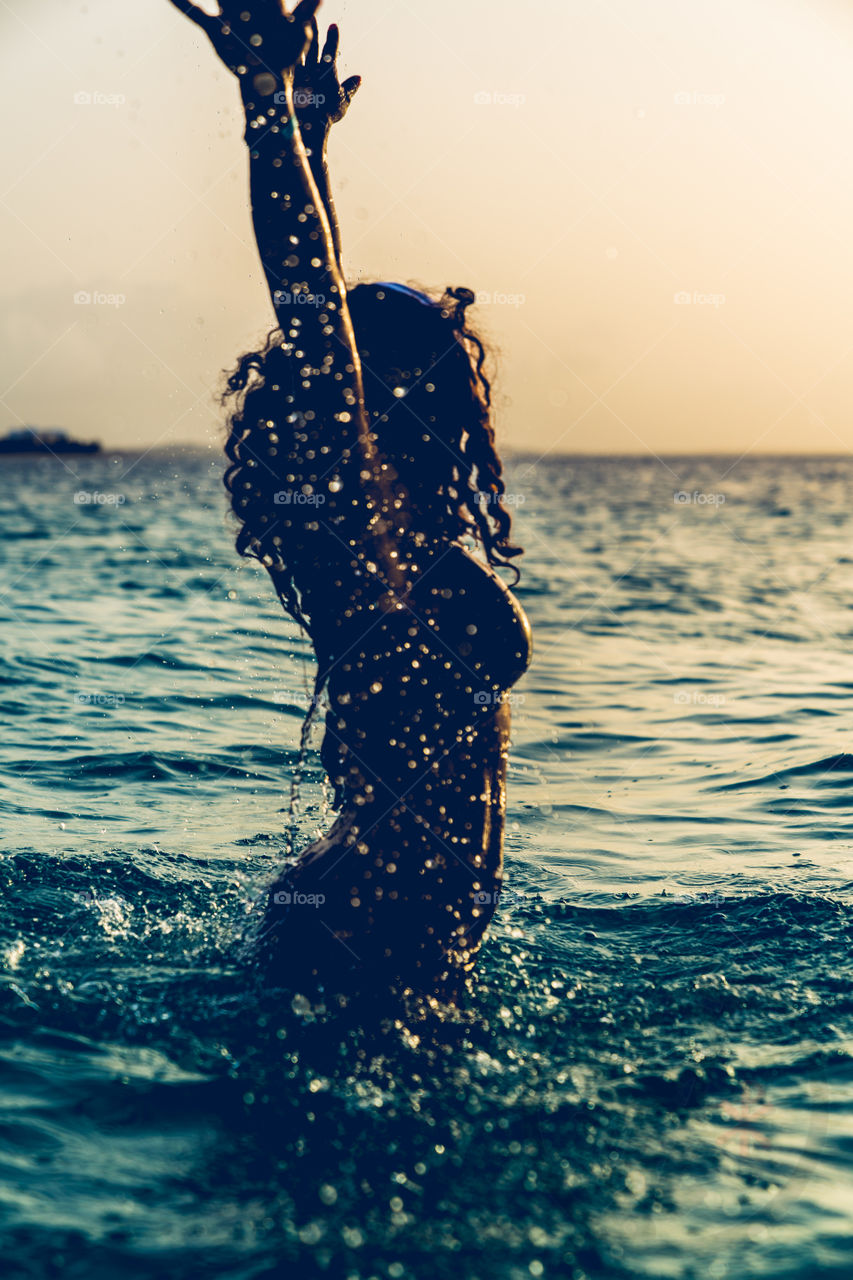 A tourist enjoys the ocean at sunsets 