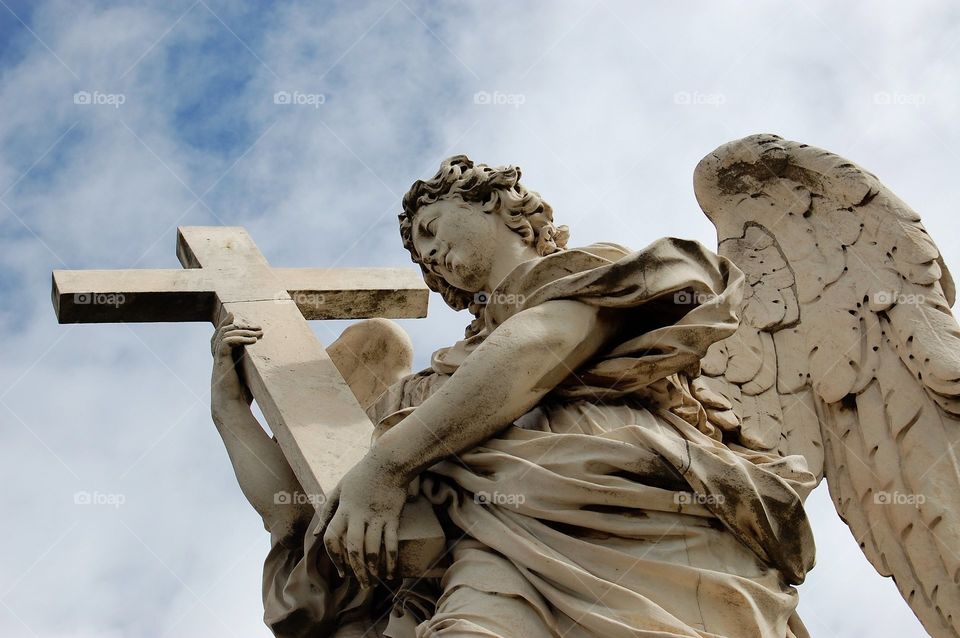 One of the 10 Angel statues lining the Ponte Sant’Angelo which spans the River Tiber in Rome. Angel with the Cross. 