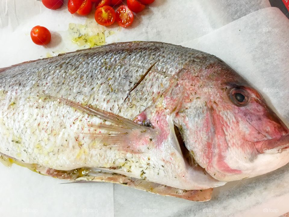 Uncooked whole red snapper dish on cutting board food preparation French Cuisine 