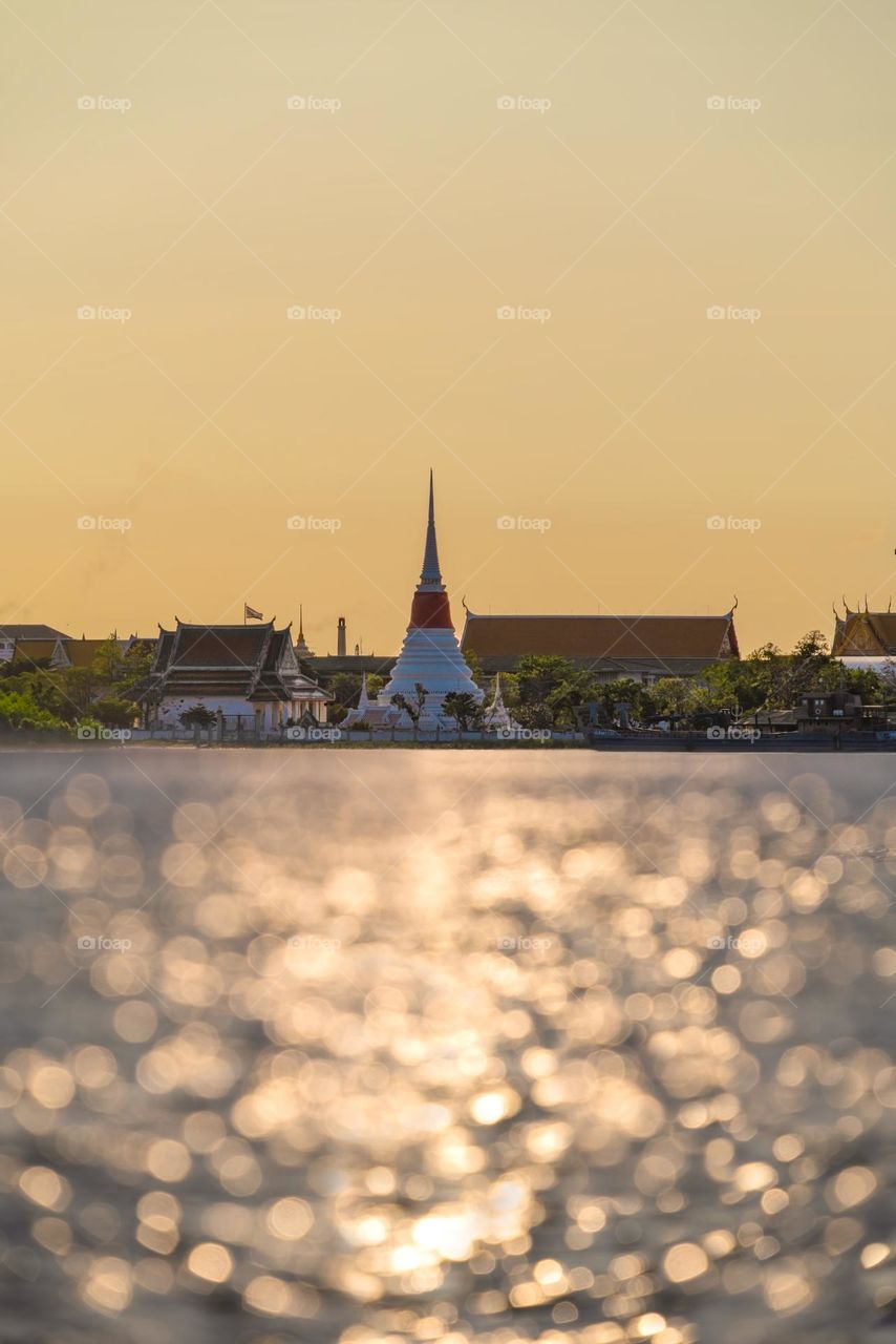 Golden sunset scene above Thai pagoda