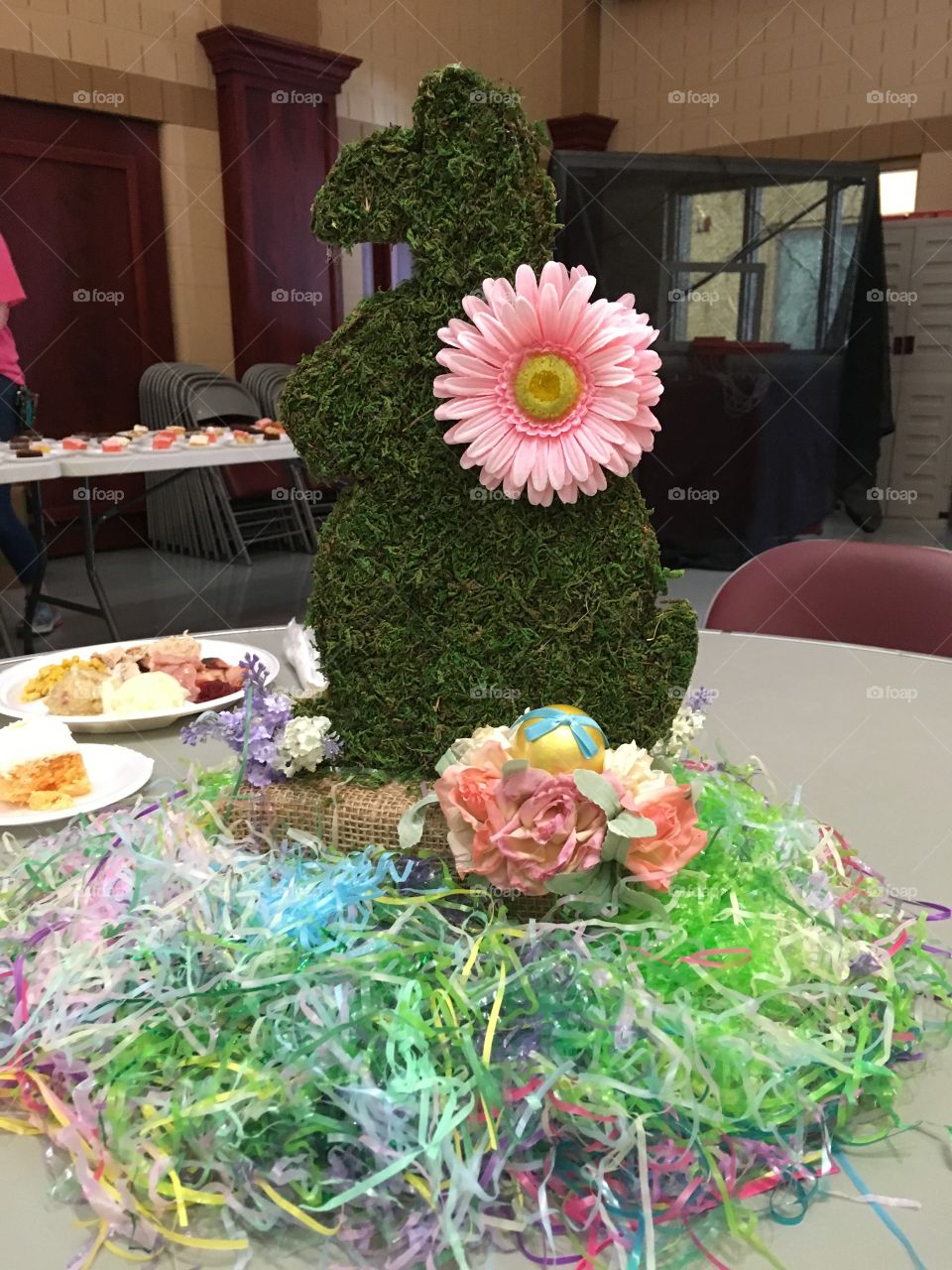 Home made colorful Easter center piece for the table. Bunny rabbit with flower and grass.