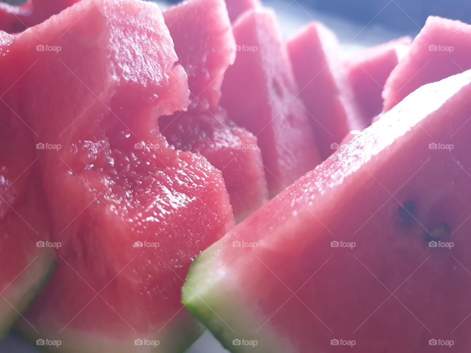 a closeup portrait of traingular pieces of sweet freshly cut red watermelon.