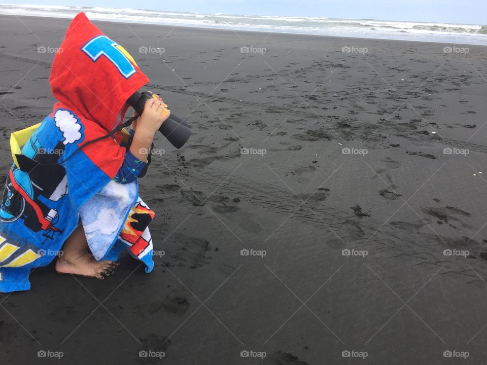 Little adventurer on a black sand beach