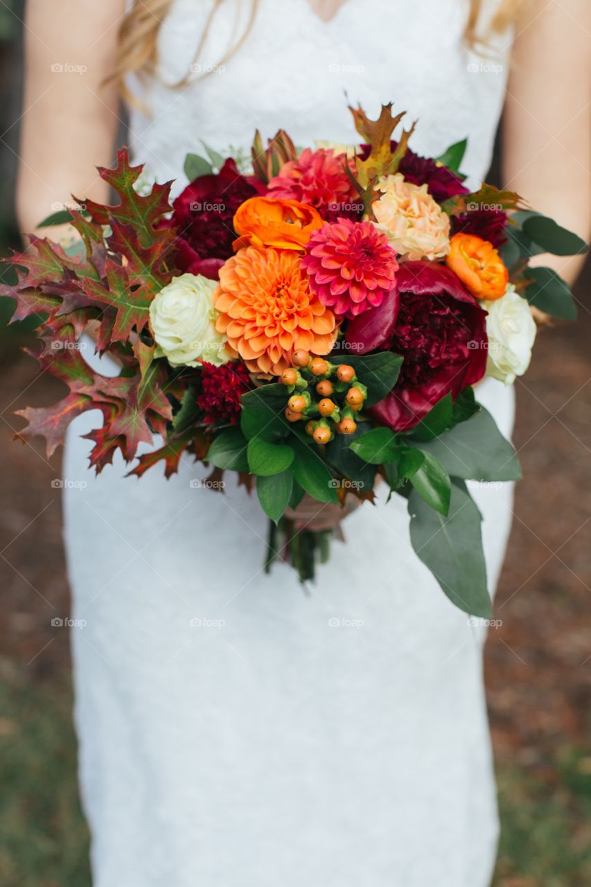 Bride holding autumn bouquet 