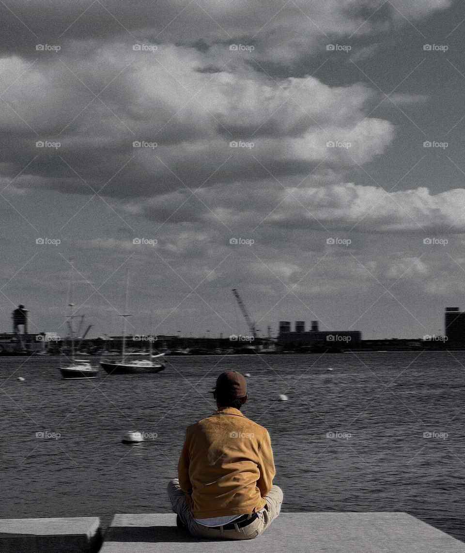 The man is looking at the ocean