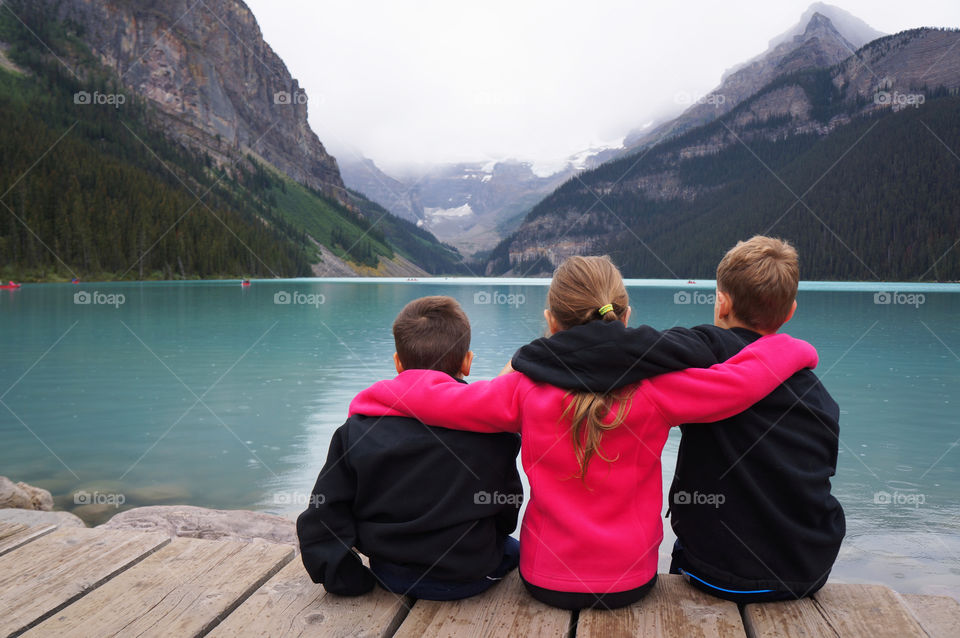Three Children sitting by Lake Louise