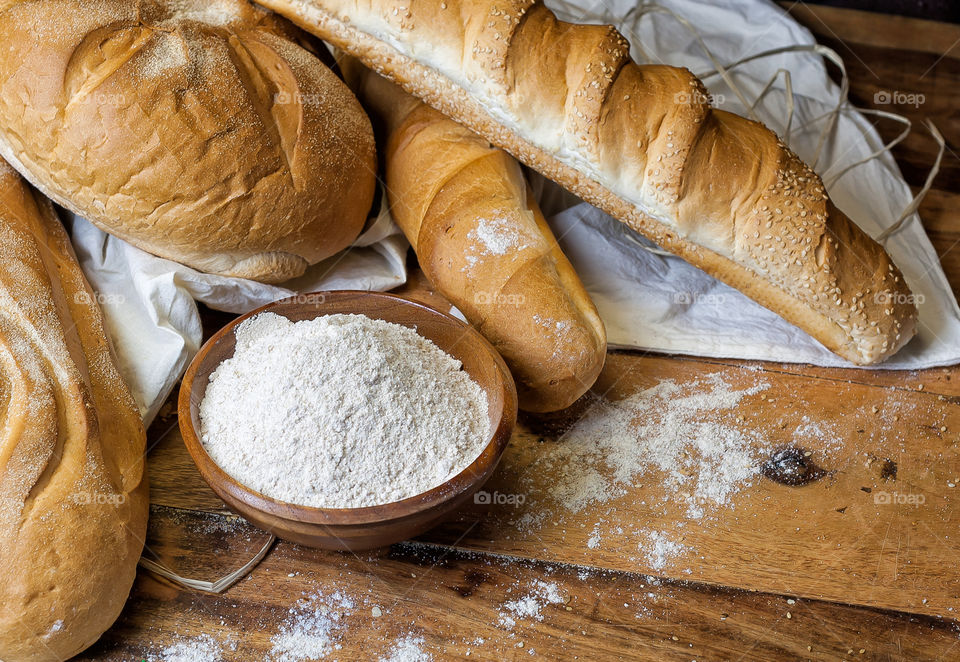 different bread and a bowl with flour