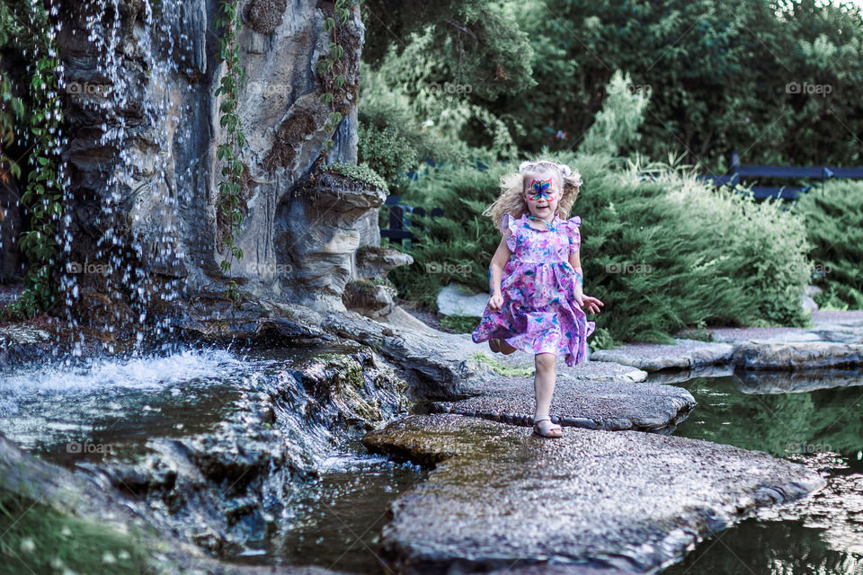 happy girl in smart dress running by the lake