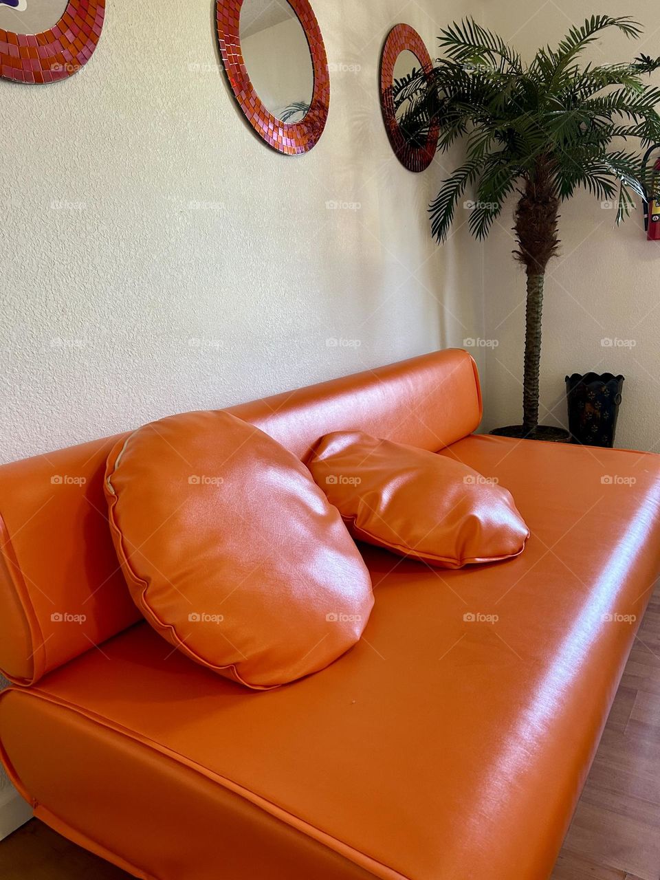 Orange couch with orange pillows 