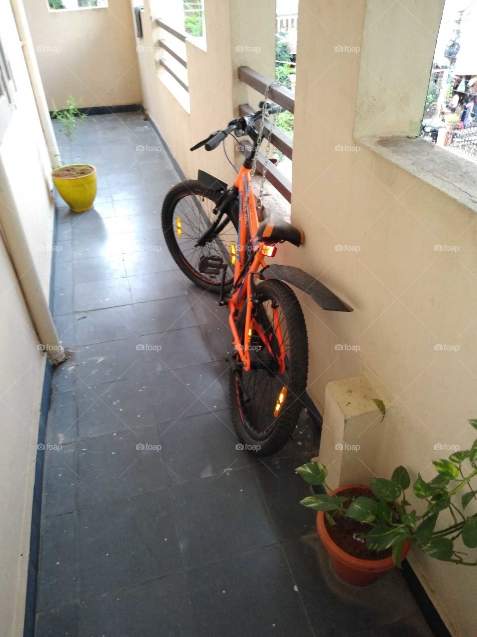 a bicycle in the balcony locked with a chain