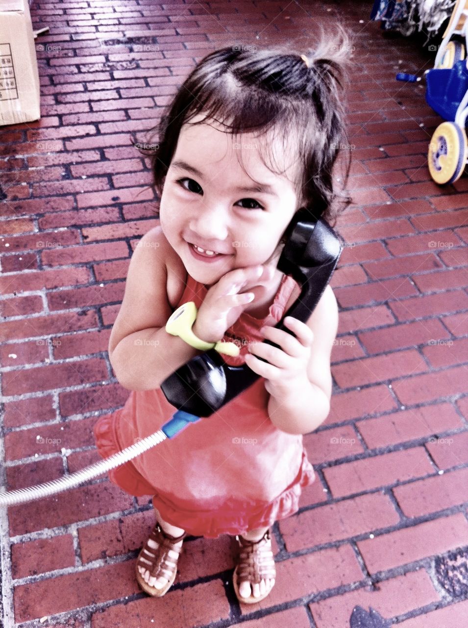 Portrait of cute girl holding telephone
