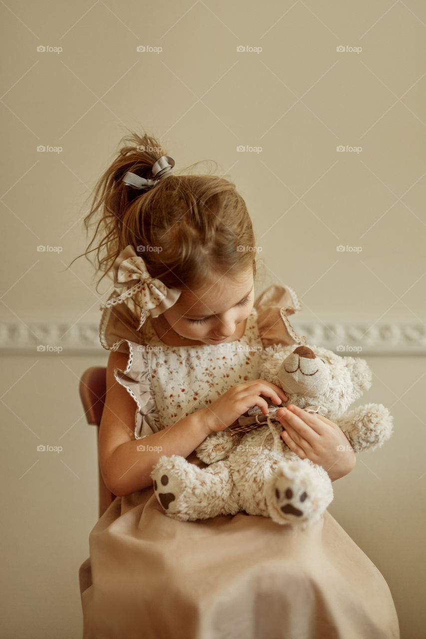 Vintage portrait of a beautiful little girl with teddy bear 