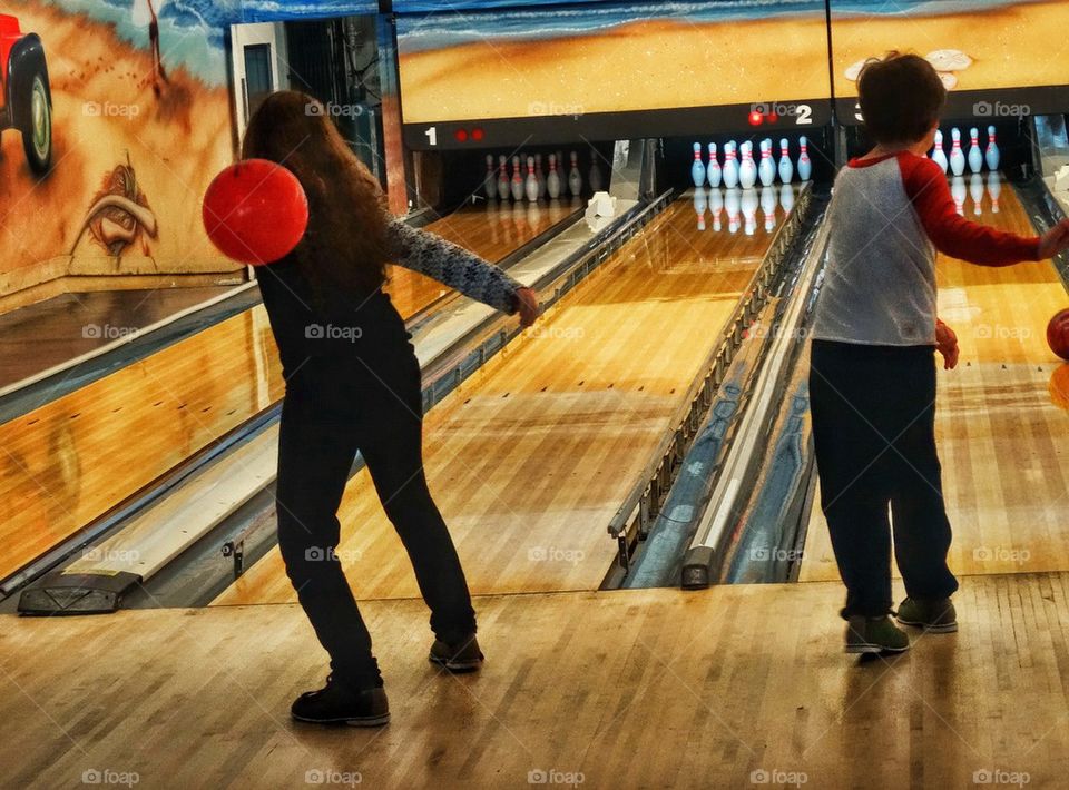 Boy And Girl At A Bowling Alley. Family Game Night
