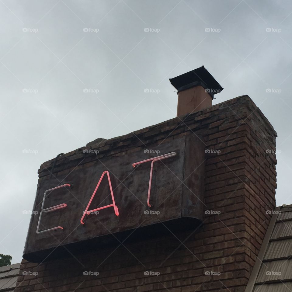Neon sign on brick chimney