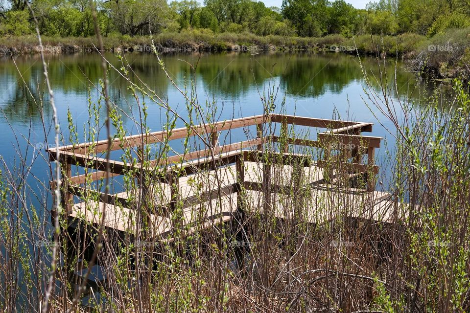 A boat dock juts out into a small body of water