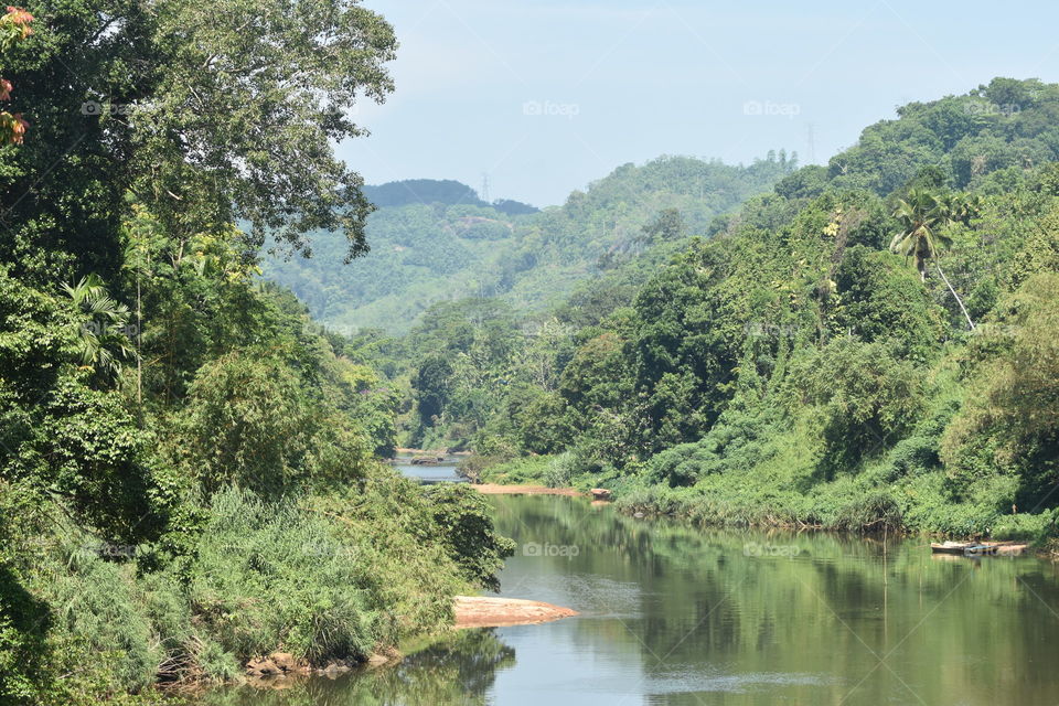 It is a beautiful river calmly flowing through forest and beautiful mountains