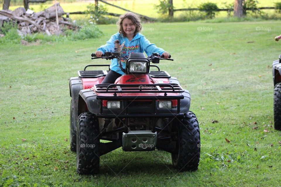 Young girl driving an ATV. 