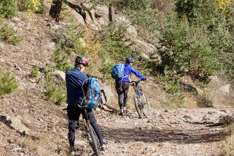Mountain bikers riding over rough terrain in the mountain
