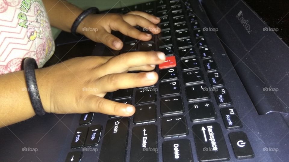 small 
child operating  in laptop playing games