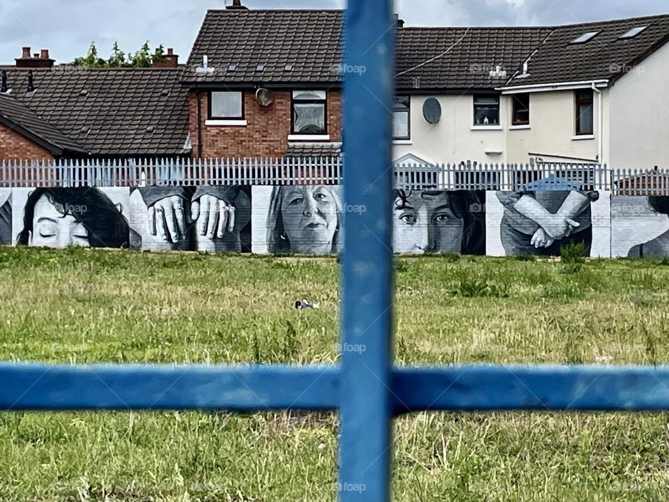 Looking through a fence partition off of Shankill Road in Belfast, Northern Ireland.