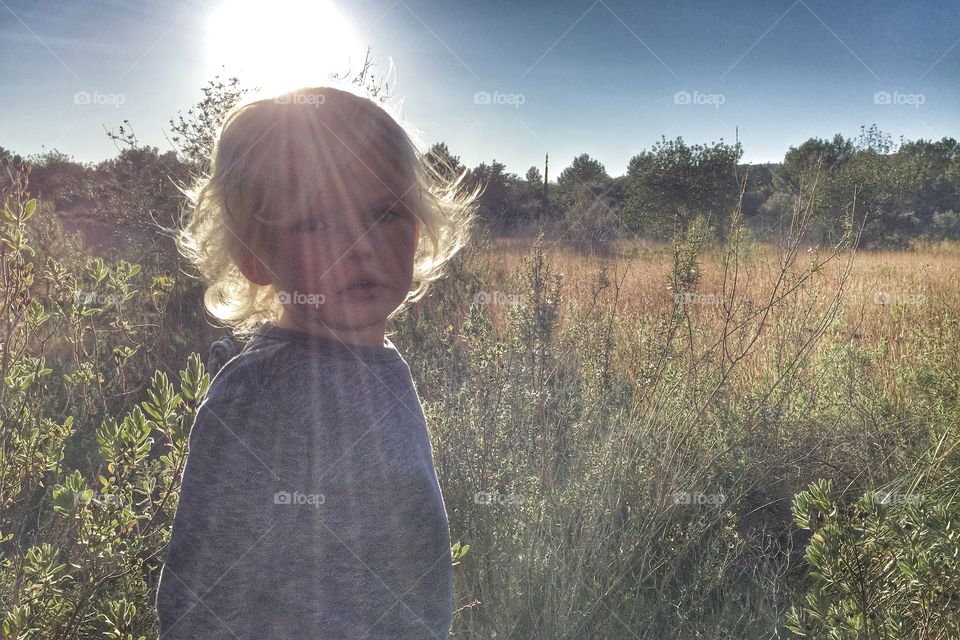 Boy standing in front of sunbeam