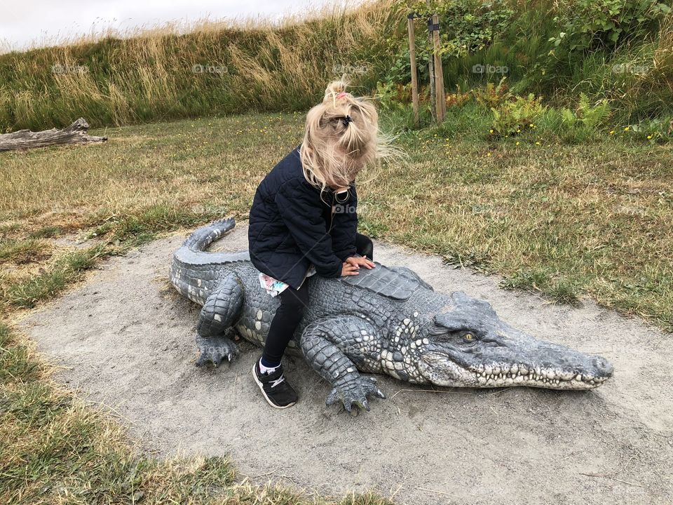 girl riding a crocodile