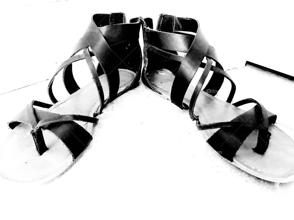 Fun stark black and white photo of cute black scrappy sandals sitting on floor! 