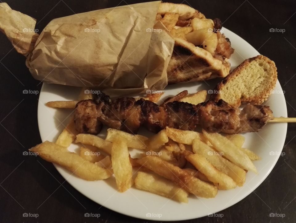 greek pita gyros french fries and meatstick on plate