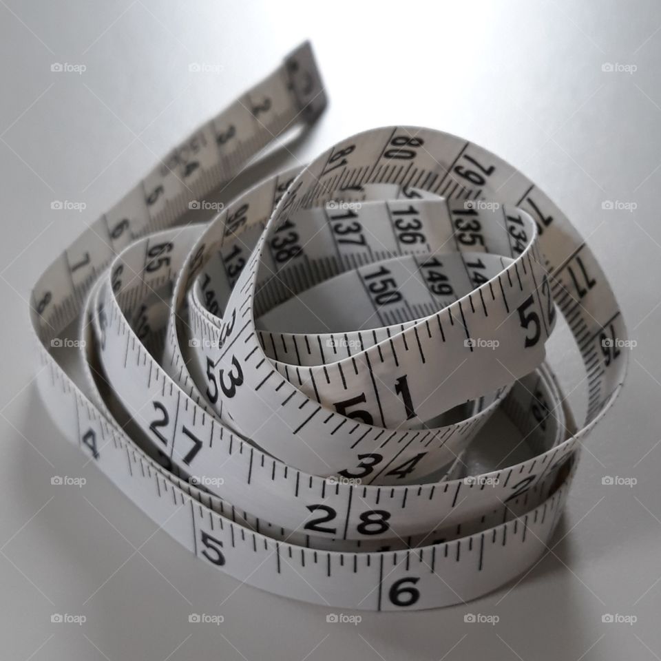 Measuring tape on white background--inches and centimeters