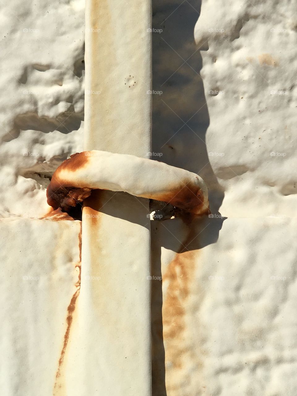 Closeup background image old white paint and rust on old stone lighthouse