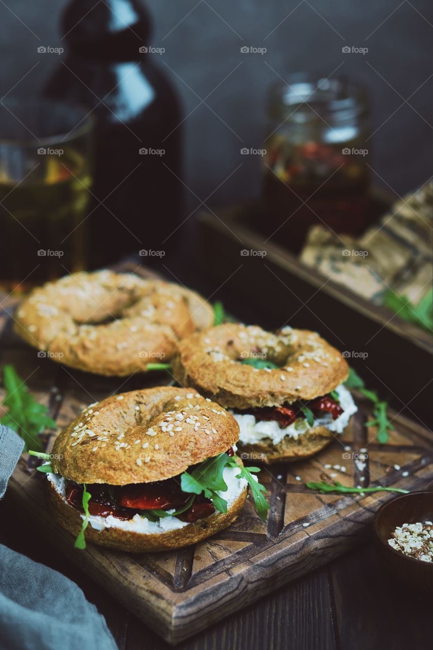 homemade bagel with chhese, tomatoes and arugula