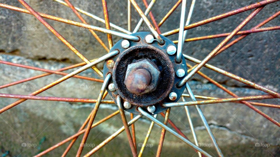 Velho cubo, eixo de roda de bike, com raiamentos enferrujados.