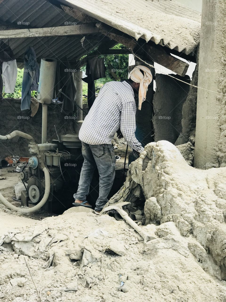 Man at motor shed for supplying current to concrete tunnel making business .