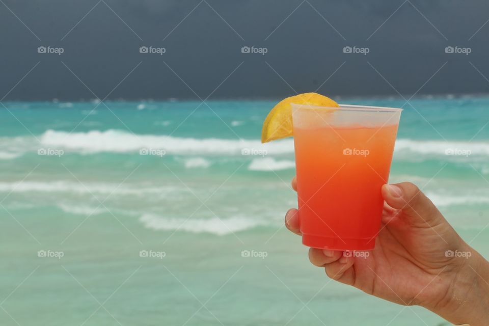 cold drink at caribbean beach with sthorm in the horizon