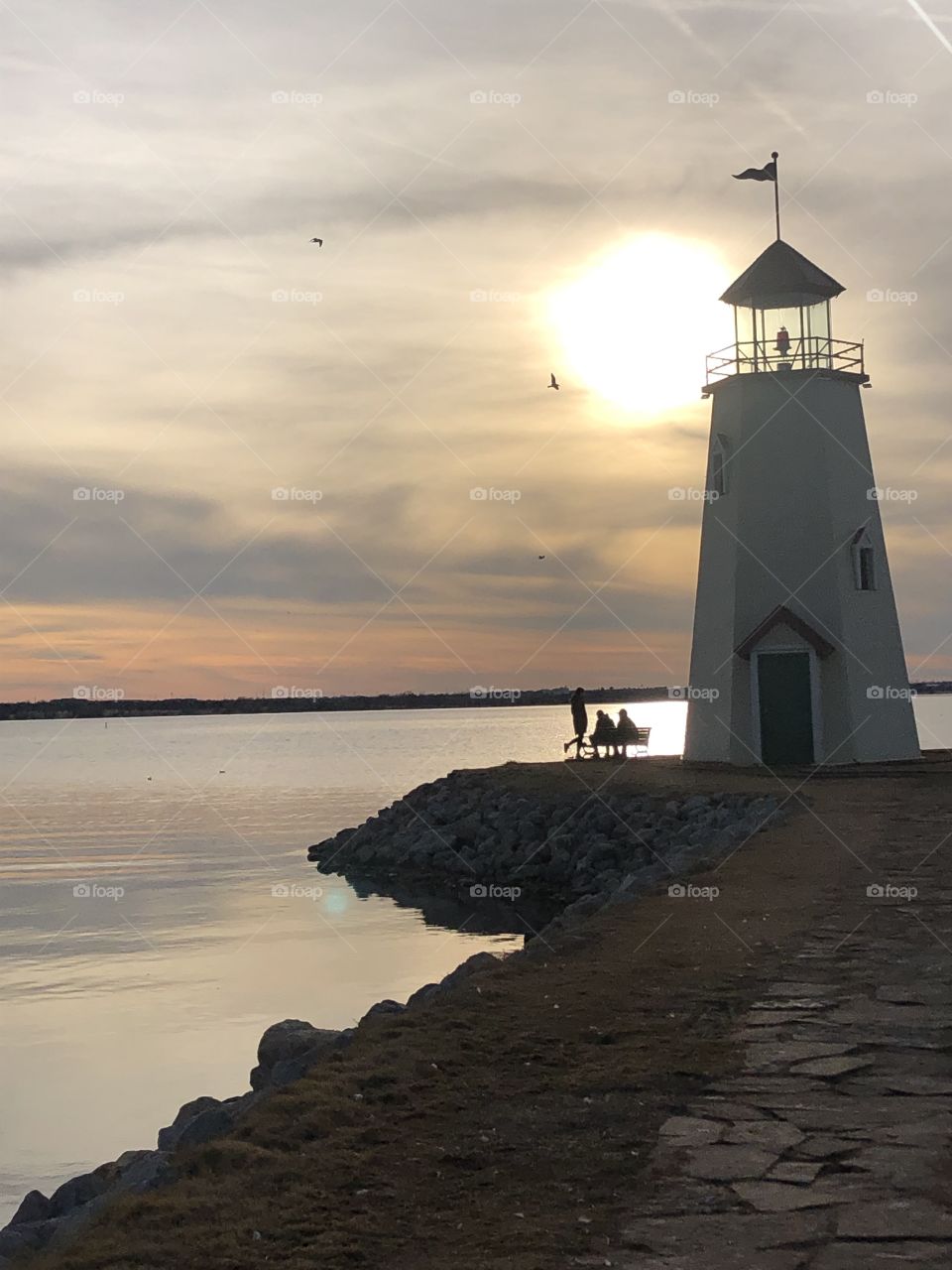 Beautiful sunset by the lake with a lighthouse 