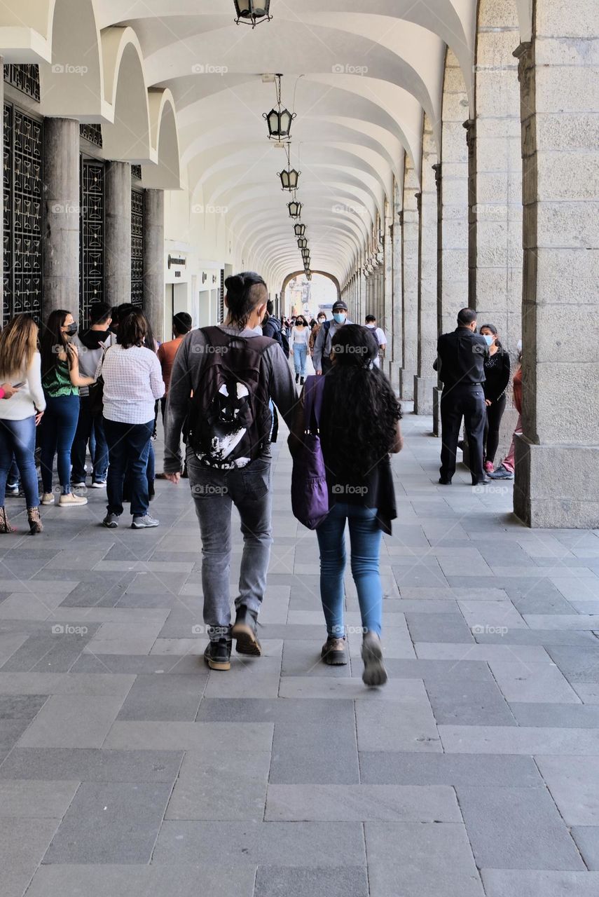 Student couple walking together through an architectural colonial passageway