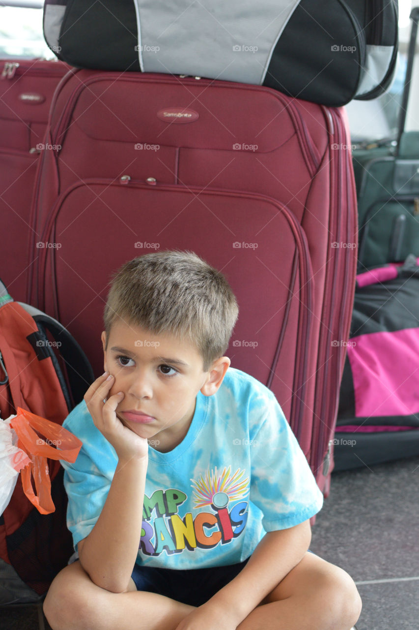 Boy sitting near bag