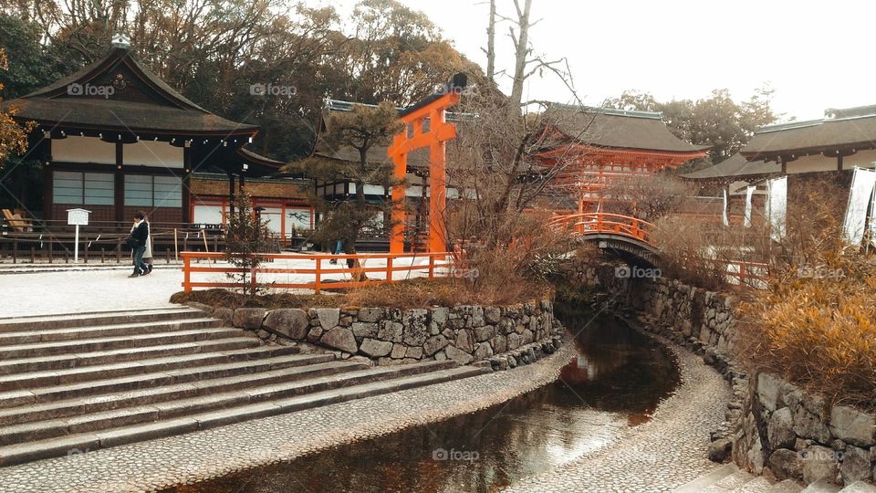 Japanese torii gate and bridge over stream
