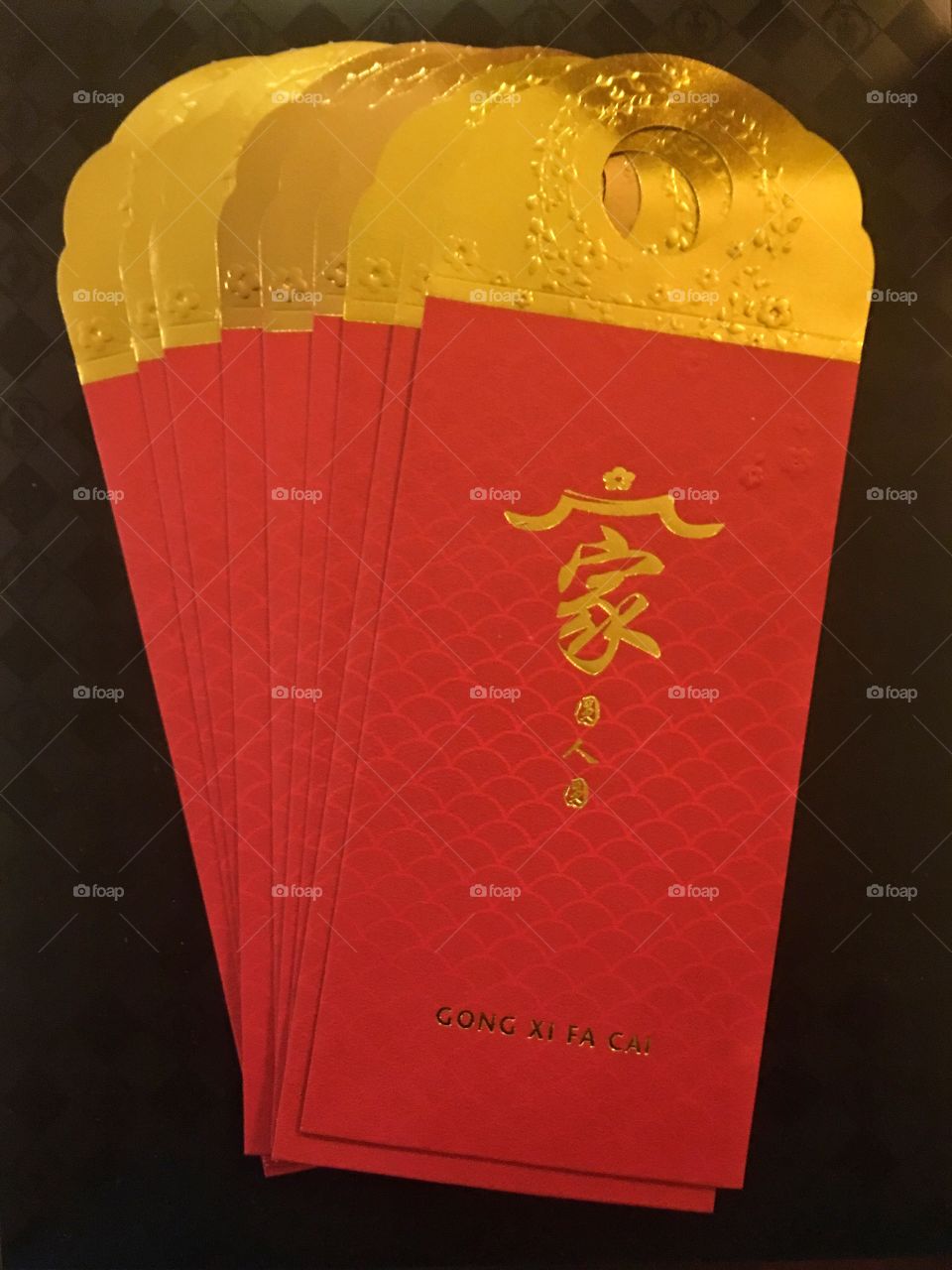 Red packets or angpau for Chinese New Year and are used to present gifts of money to the young and single by older married couples. 
The characters say "Jia yen ren yen" meaning "happy family". Red is a very important positive lucky colour to Chinese and is used liberally for decorations during auspicious events like Chinese New Year. 