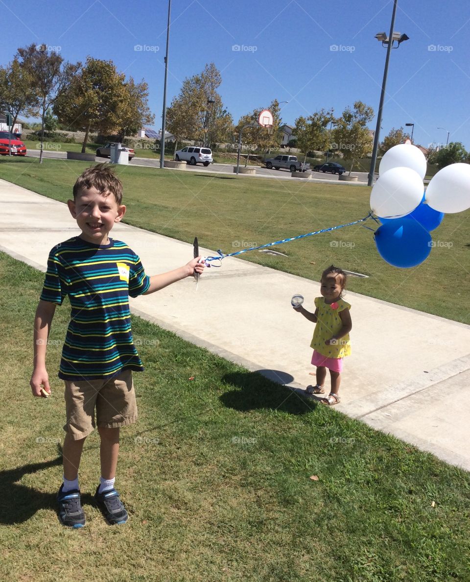 Boy with blue & white balloons