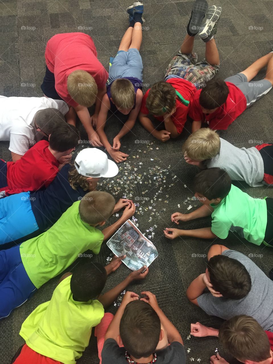 A group of boys work together to assemble a 500-piece puzzle