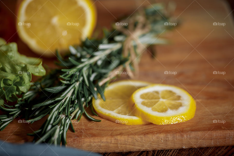 Lemon with rosemary on wooden board