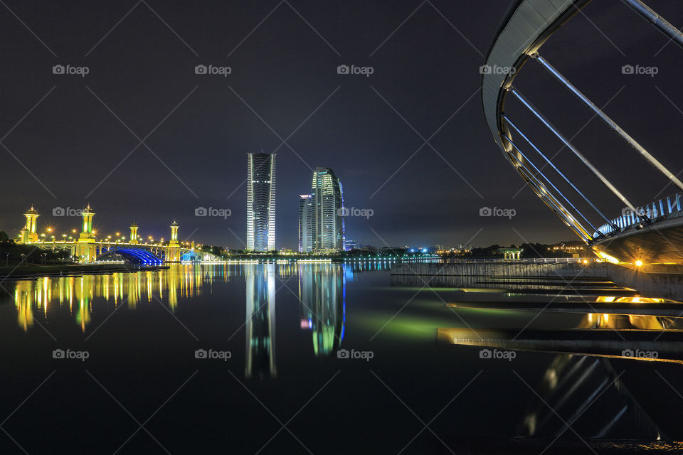 Illuminated city at night reflecting on the sea