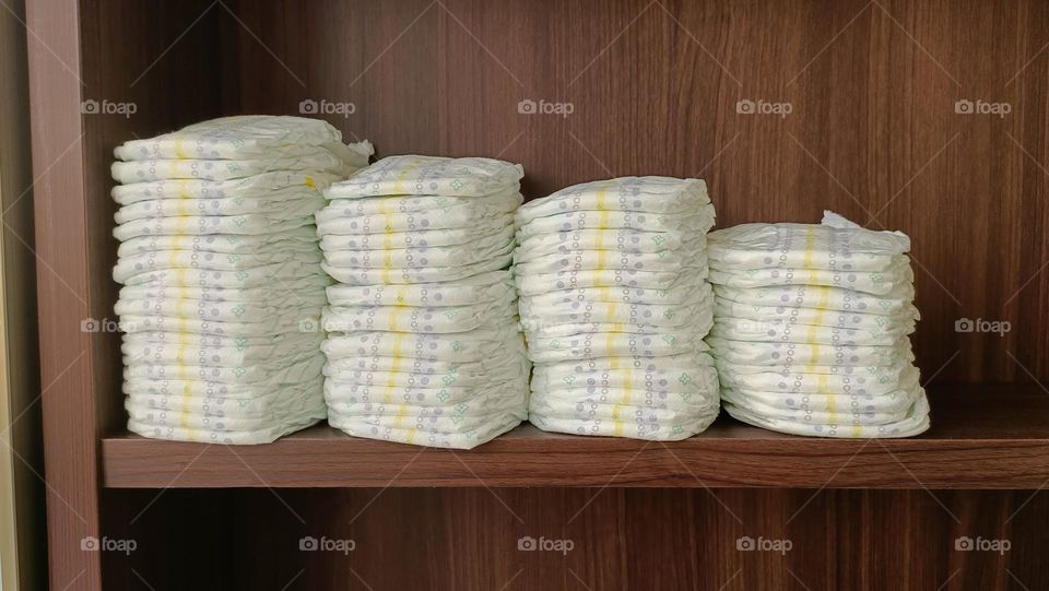 Baby diapers stacked on the shelf.