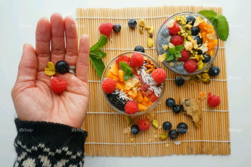 Healthy Fresh Fruit Smoothie Bowl - creamy raspberry smoothie topped with peach, seeds, dry coconuts,  nuts, blueberry and strawberry