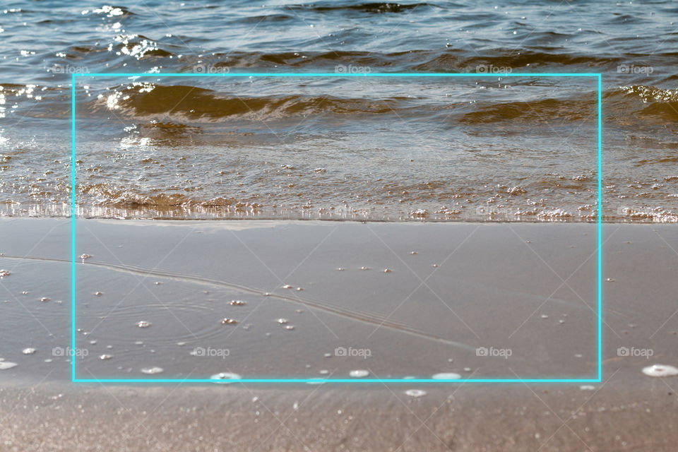 Waves on the sand with glowing frame, space for text 