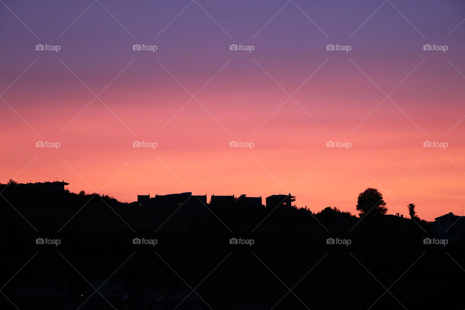 Silhouettes of buildings against the sky at sunset. Abstract image.