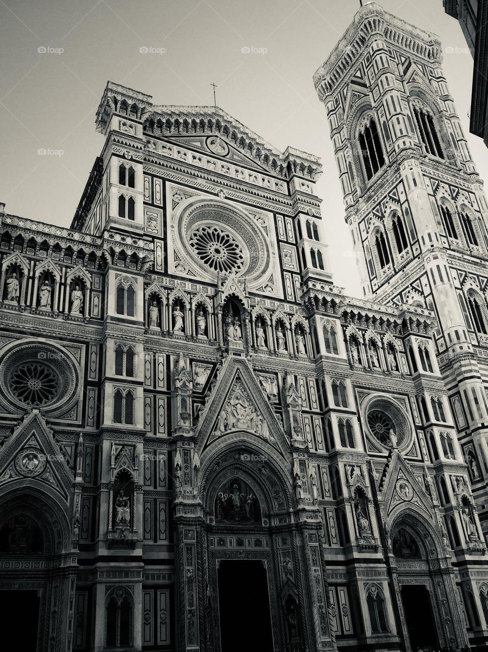 the splendid richly decorated and chiseled facade of the famous cathedral of Santa Maria del Fiore in Florence, an example of Italian architecture in black and white